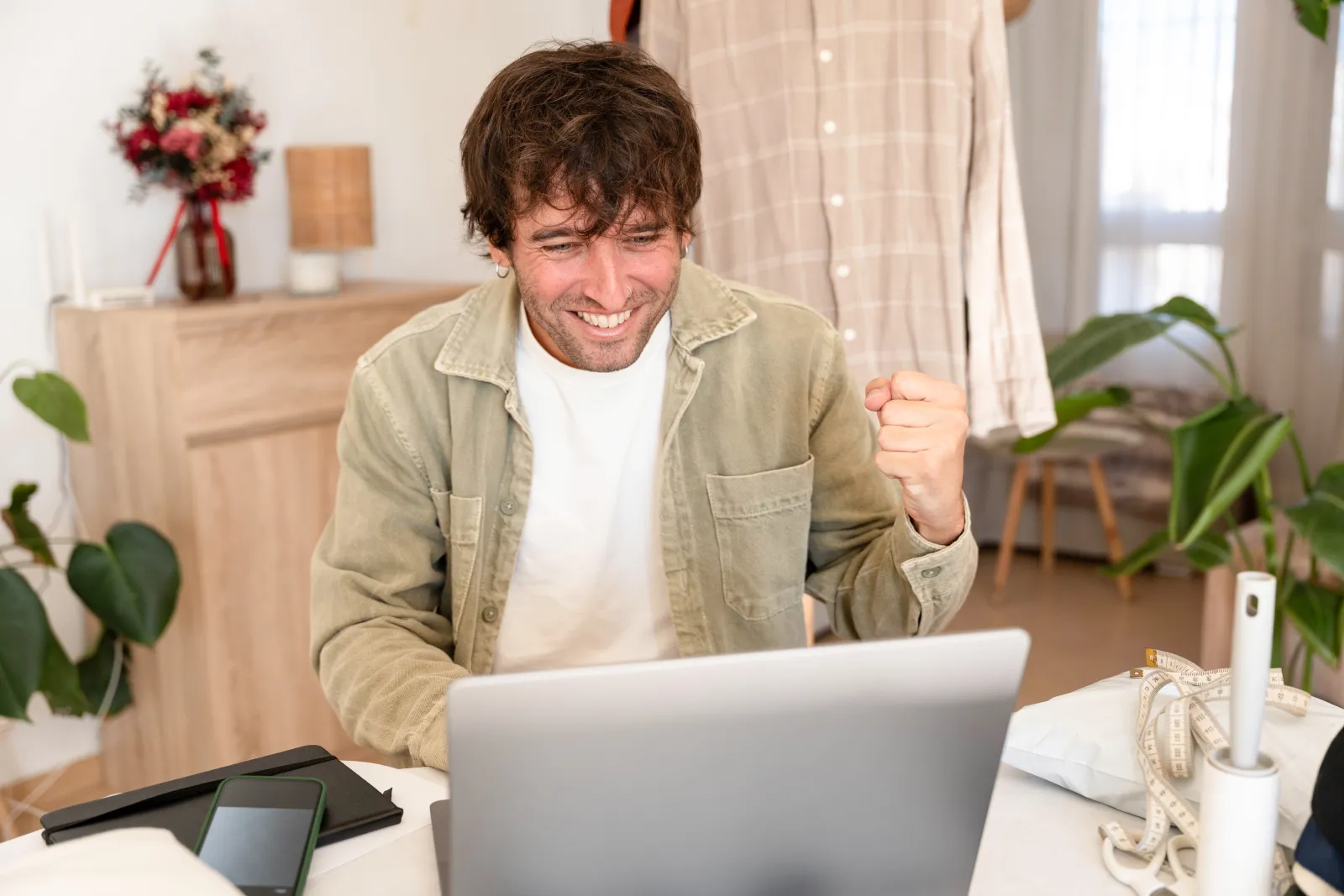 Creator celebrating a win at their laptop